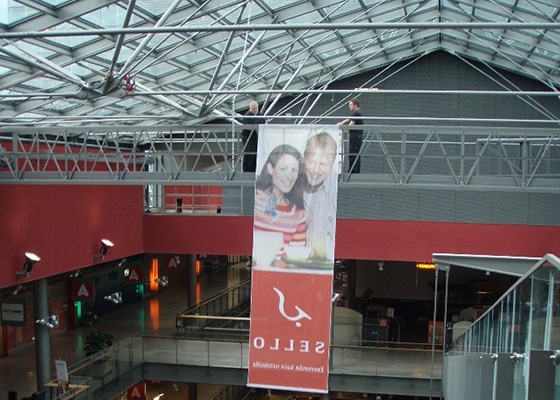 People hanging an advertisement on a gantry